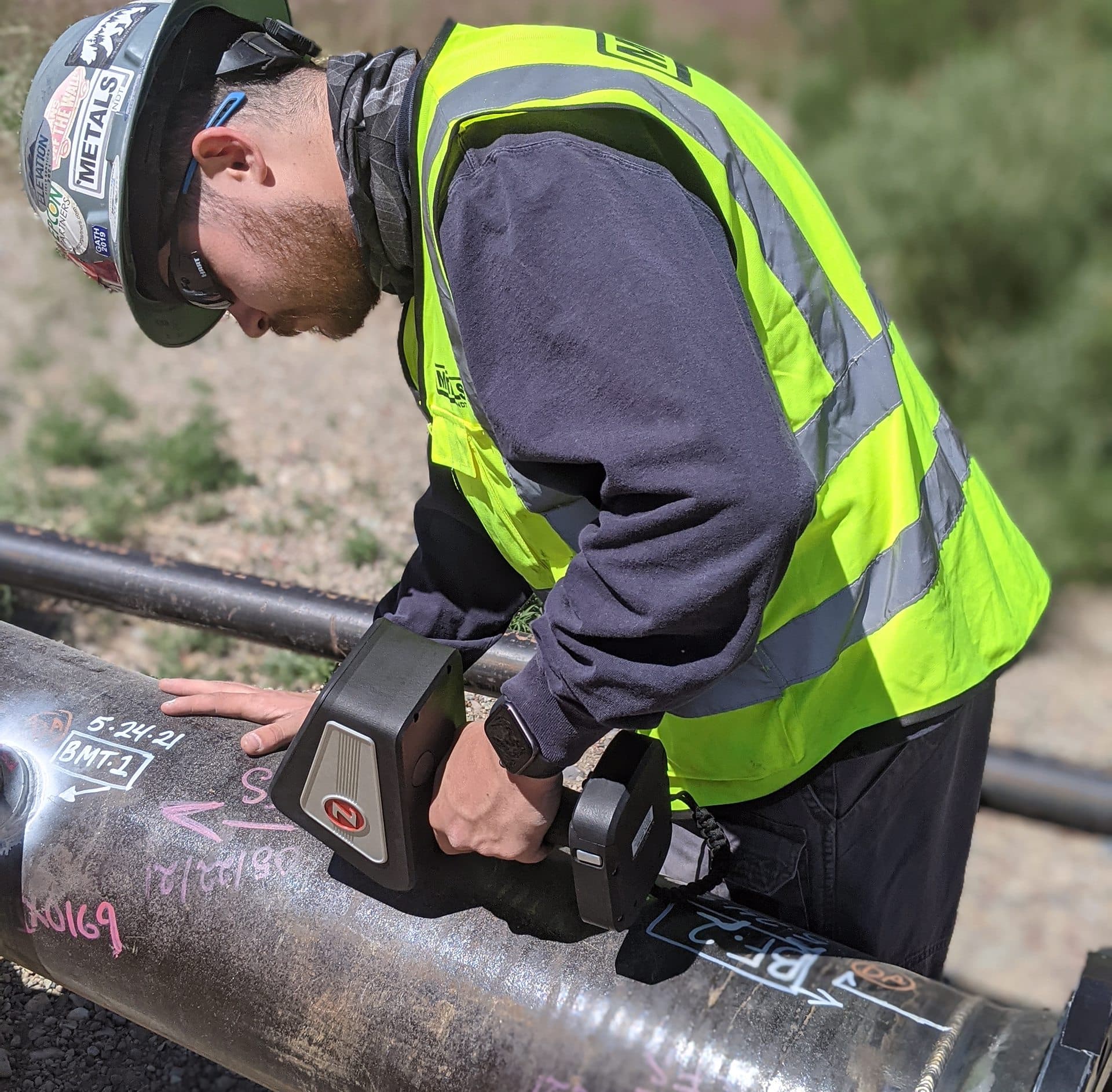 Technician performs Positive Material Identification (PMI) testing on pipeline